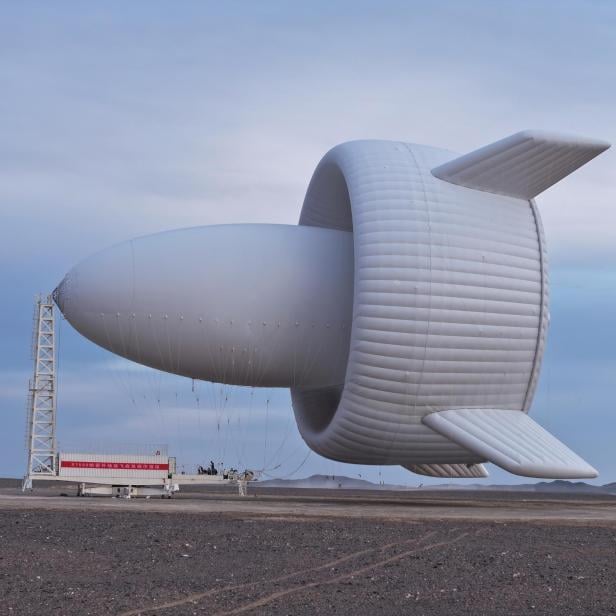 Ein großer, weißer, ungewöhnlich geformter Windrad-Prototyp steht in einer kargen Landschaft.