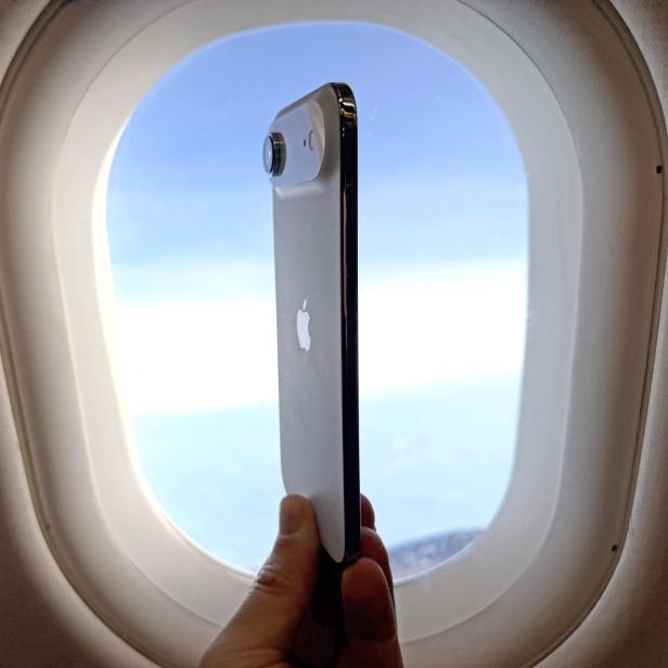 iPhone Air vor einem Flugzeugfenster