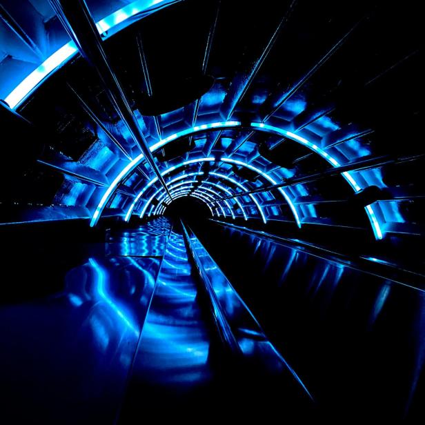 Dunkler Tunnel mir blauen Neonröhren.