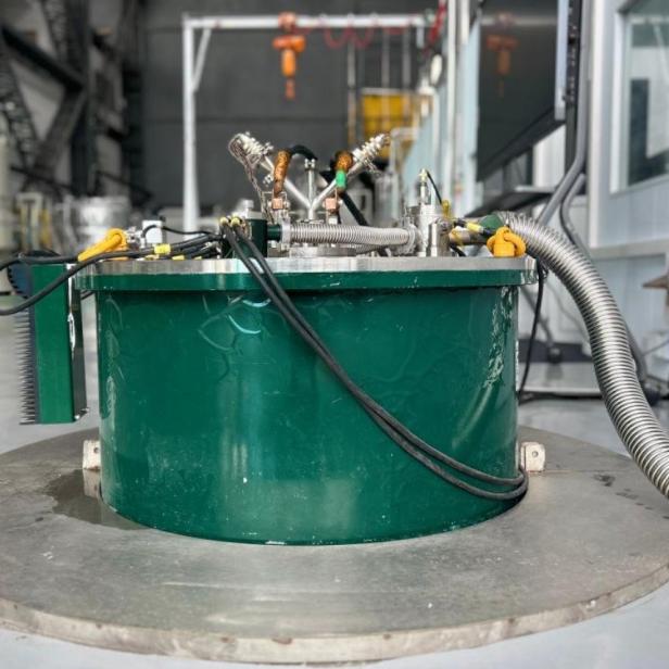 ein grünes Gerät mit silbernen und schwarzen Röhren