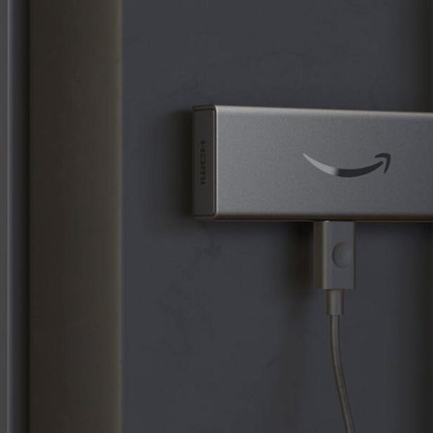 Ein älteres Modell des Fire TV Stick steckt an einem TV-Gerät
