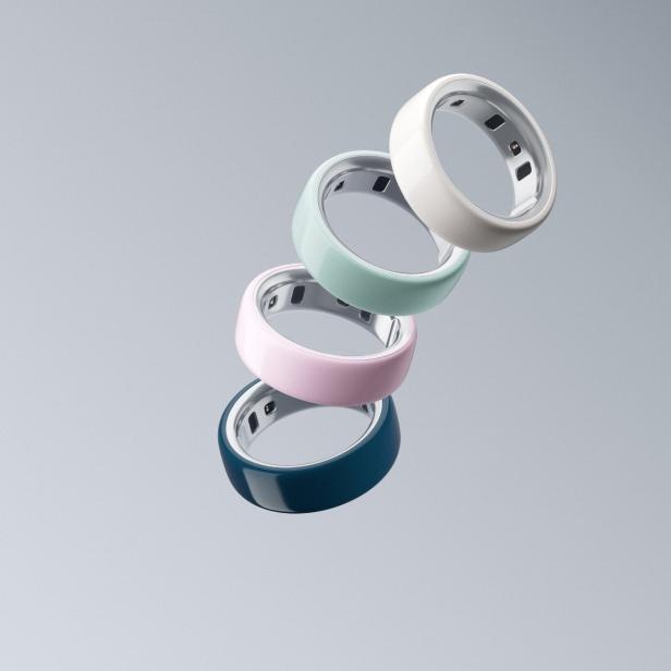 die vier bunten Oura Ringe schweben vor grauem Hintergrund