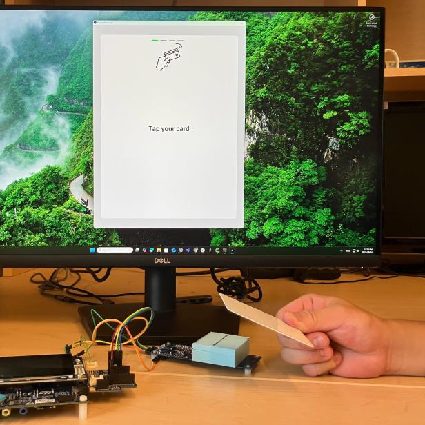 Ein Bildschirm und davor der Prototyp des NFC-Terminals