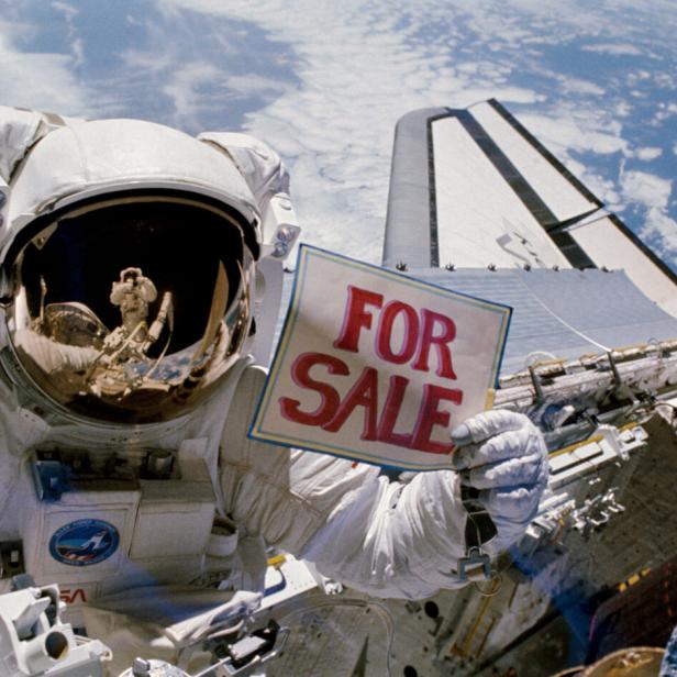 Ein NASA-Astronaut hält ein "For Sale"-Schild. (Symbolbild)