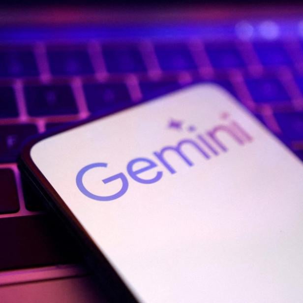 Ein Smartphone mit dem Gemini-Logo liegt auf einer Laptop-Tastatur.
