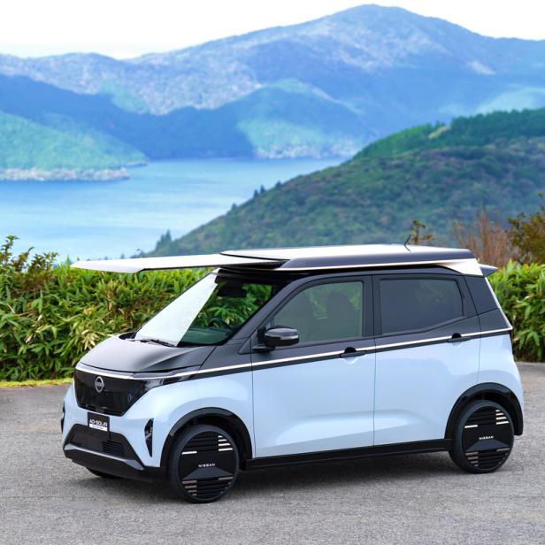 Nissan Sakura mit Solardach vor einem See mit Bergen