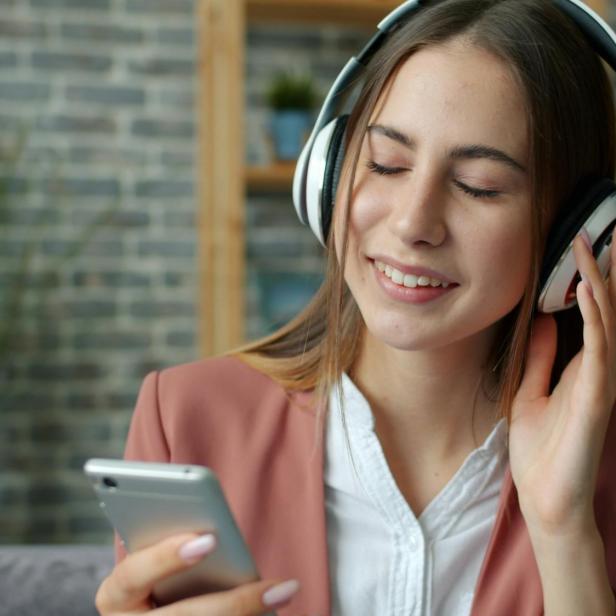 Eine Frau, die mit ihren Kopfhörern Musik hört 