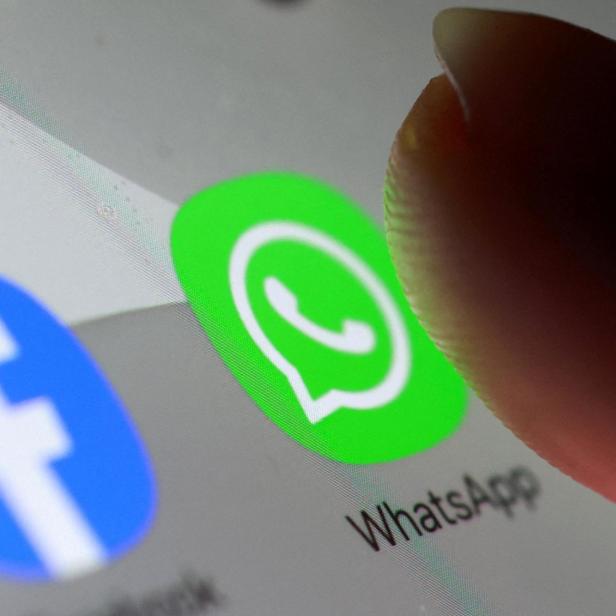 Ein Finger tippt auf das grüne WhatsApp-Symbol auf einem Smartphone-Bildschirm.