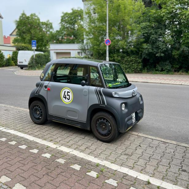 Ein Microcar steht am Straßenrand, wie sie künftig mit nachhaltigen Natrium-Ionen-Batterien aus Holz betrieben werden könnten.