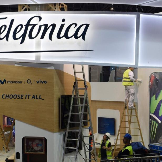 Arbeiter bereiten einen Stand von Telefónica mit Movistar-Logos vor.