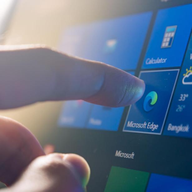 ein Finger tippt auf das Microsoft Edge Symbol eines Touchscreens