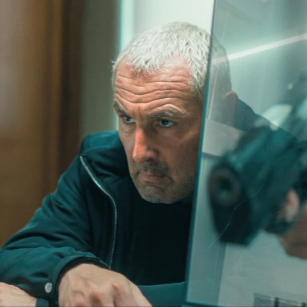 Szenenbild Zone 3 - Frau mit Waffe, Ermittler sitzt an einem Schreibtisch