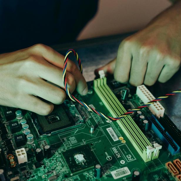 Eine Person schraub am Innenleben eines Computers herum