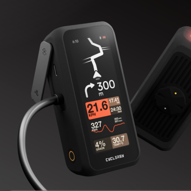 Fahrradcomputer mit Displayanzeige und integriertem Frontlicht in dunkler Umgebung.