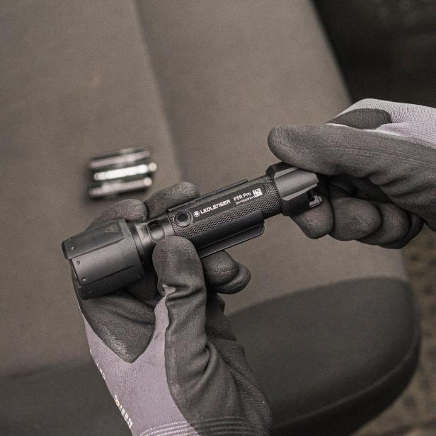 Eine Person mit Handschuhen hält die Taschenlampe P5R Pro von Ledlenser in den Händen.