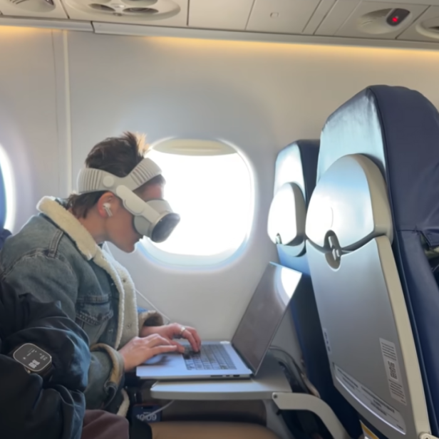 Eine Person trägt eine Apple Vision Pro in einem Flugzeug