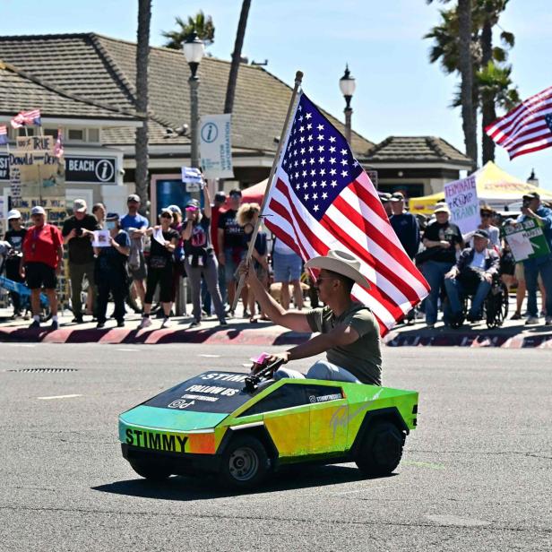 Ein Mann fährt auf einem Spielzeuggefährt und schenkt eine US-Flagge
