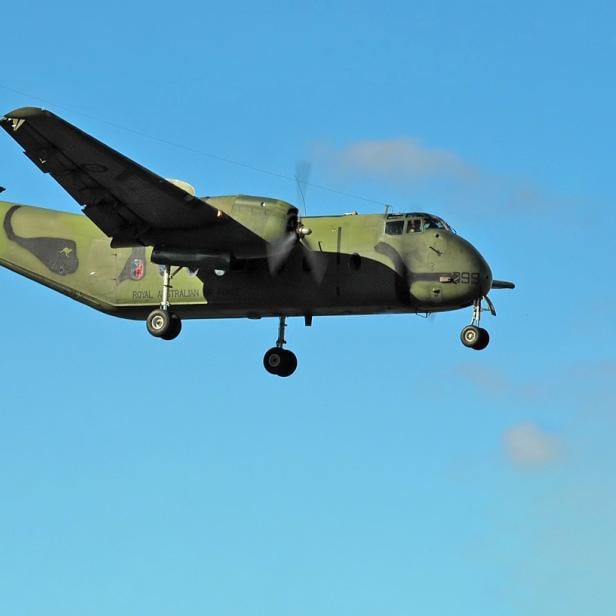 Eine de Havilland Canada DHC-4 Caribou Transportmaschine fliegt vor blauem Himmel