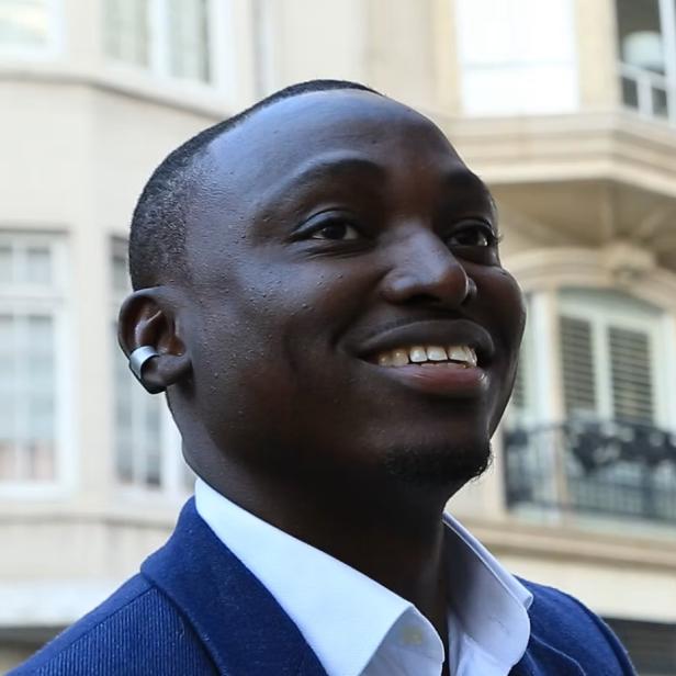 Mann mit smartem Ohrring-Wearable vor einem Gebäude in der Stadt.