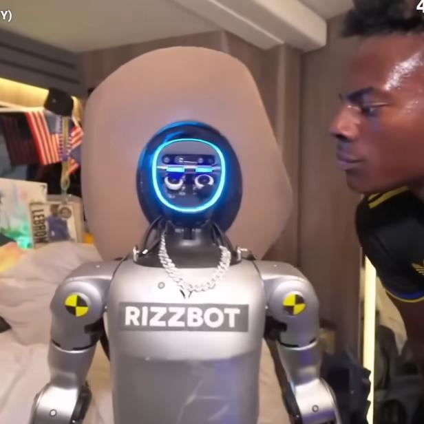 IShowSpeed steht vor einem silbernen "Rizzbot"-Roboter mit leuchtenden Augen.