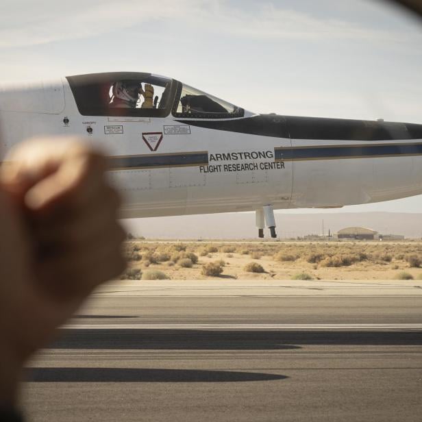 Das NASA-Forschungsflugzeug ER-2 mit dem AVIRIS-5-Sensor steht auf einer Landebahn des Armstrong Flight Research Center, im Vordergrund ein erhobener Daumen.
