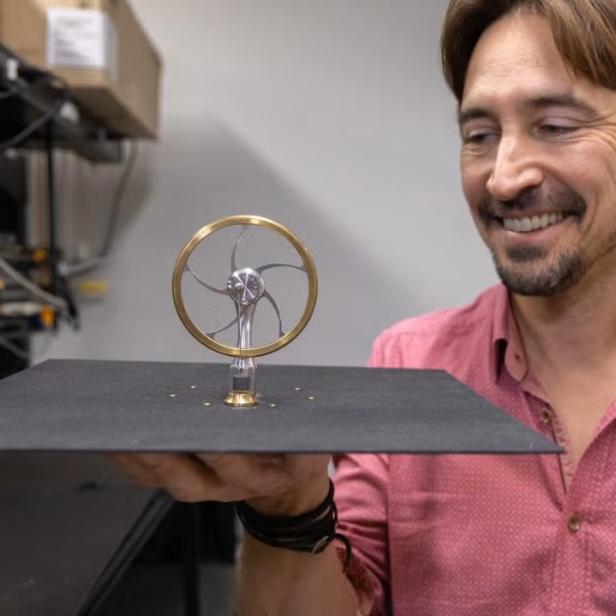 Ein Forscher der UC Davis hält einen Stirlingmotor-Prototyp, der durch nächtliche Abstrahlung von Wärme ins Weltall Strom erzeugen kann.