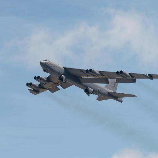 Eine B-52H fliegt am Himmel mit ausgefahrenem Fahrwerk und sichtbaren Triebwerken.