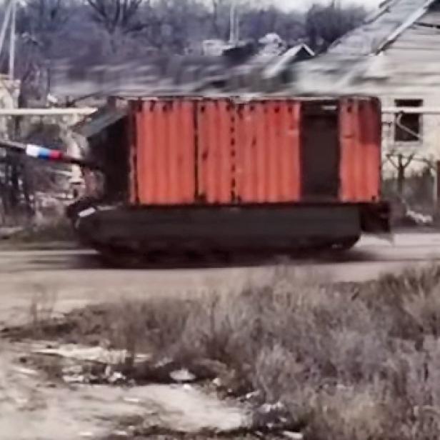 Russischer Container-Panzer fährt auf einer staubigen Straße