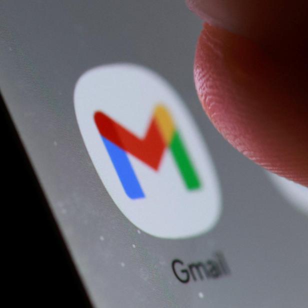 Ein Finger tippt auf das Gmail-Symbol auf einem grauen Bildschirm.