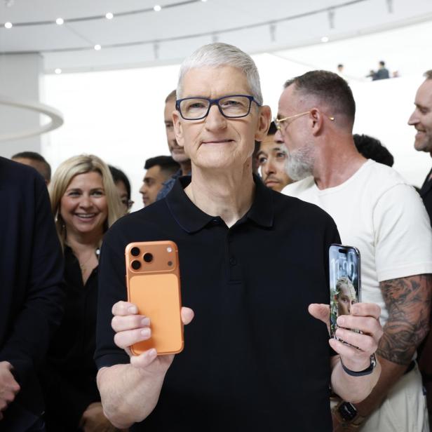 Apple-Chef Tim Cook hält 2 iPhones in der Hand
