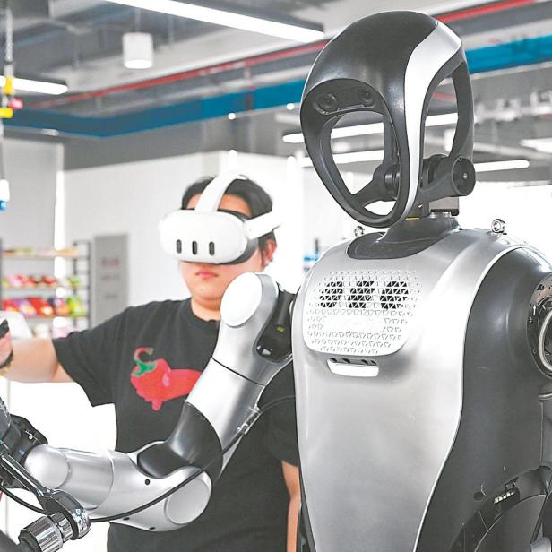 Person mit VR-Headset trainiert humanoiden Roboter in einem modernen Laborraum.