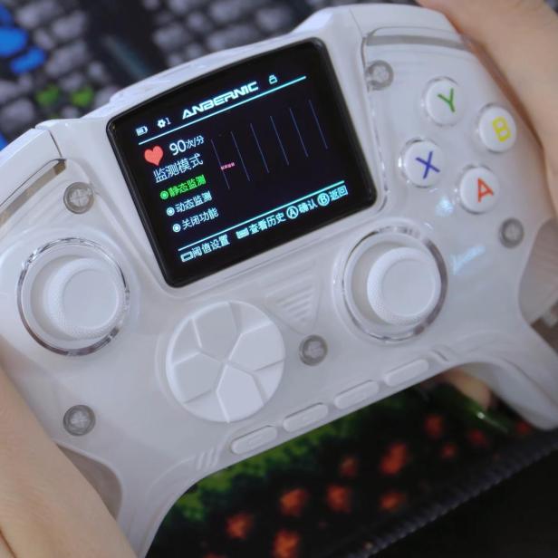 Hände halten weißen Controller mit Display, das den Puls in Echtzeit anzeigt.