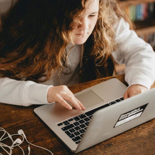 ein Mädchen sitzt vor einem Laptop 