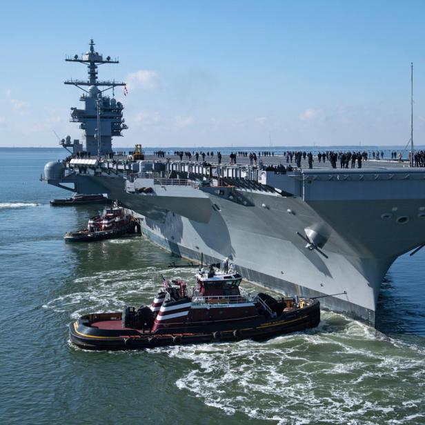 Flugzeugträger USS John F. Kennedy fährt am Meer unter leicht bewölktem Himmel