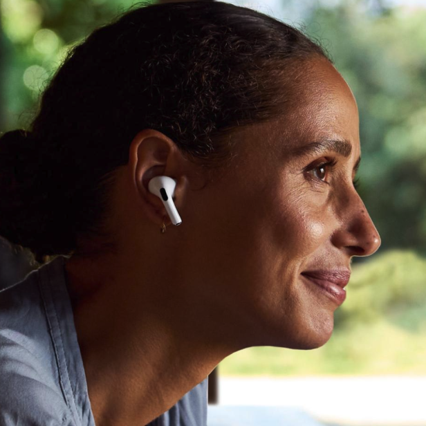 Eine Frau trägt weiße AirPods-Kopfhörer.