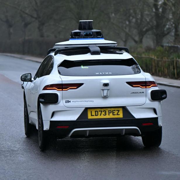 Ein weißer Jaguar mit Waymo-Technologie und dem Kennzeichen LD73 PEZ fährt auf einer Straße.