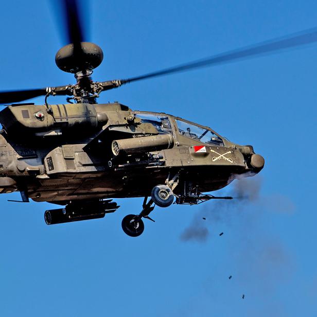 Kampfhubschrauber AH-64 Apache feuert seine 30-mm-Kanone im Flug ab.