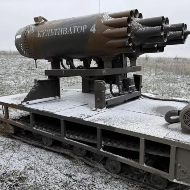 Ferngesteuertes Kettenfahrzeug mit montierten Raketen-Startbehältern auf verschneitem Feld.