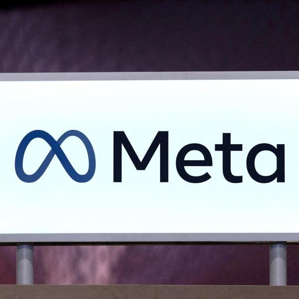 Leuchtendes Schild mit dem Meta-Logo und dem Schriftzug „Meta“ auf hellem Hintergrund.