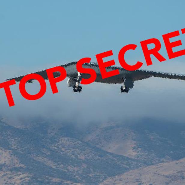 Ein B-21 Stealth-Bomber fliegt vor Bergen, darüber steht in Rot „TOP SECRET“.