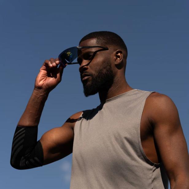 Ein Sportler setzt die Engo3-Smartbrille auf, die Trainingsdaten direkt im Sichtfeld anzeigt.