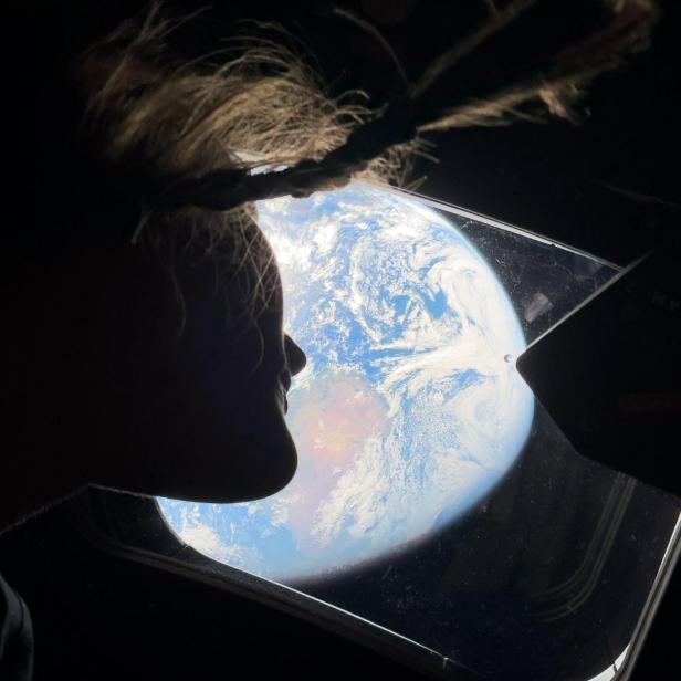 Astronautin Christina Koch blickt aus der Orion-Raumkapsel auf die Erde, aufgenommen mit einem iPhone 17 Pro Max während der Artemis-II-Mission.