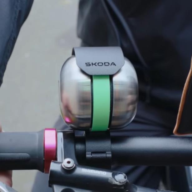 Škoda DuoBell Fahrradklingel mit grünem Band am Lenker eines Fahrrads montiert.