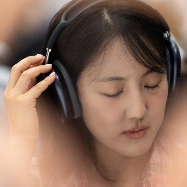 Eine Person hört Musik über Apple AirPods Max Kopfhörer