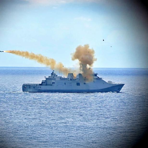 Eine Fregatte auf dem Meer startet eine Rakete, die nach links fliegt