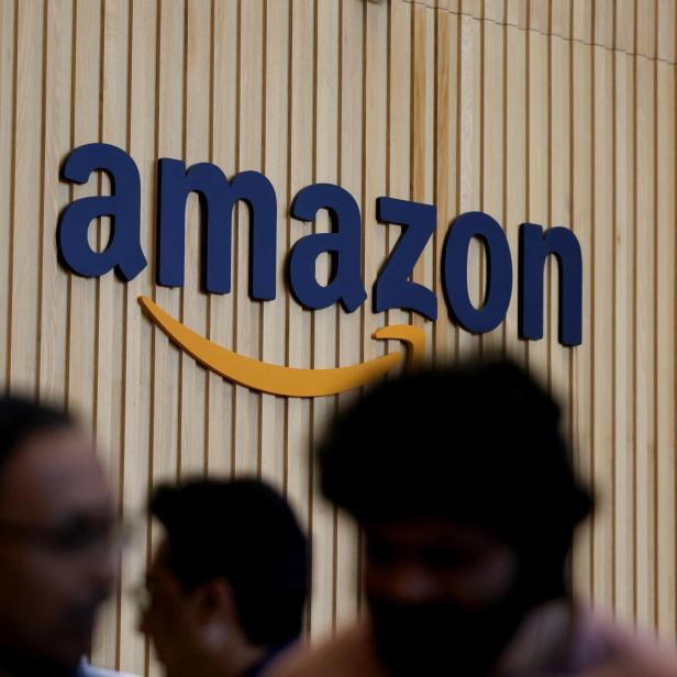 Amazon Logo mit Köpfen  im Vordergrund.