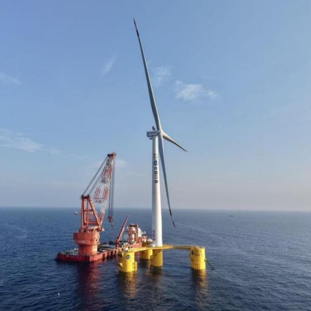 Die schwimmende 16-Megawatt-Windkraftanlage der Three Gorges Corporation (CTG) steht auf einer gelben Plattform weit vor der Küste im Meer.