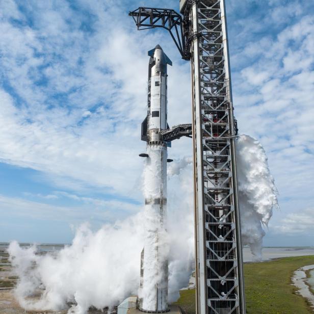 Die Starship-Rakete steht rauchend auf der Startrampe in Texas unter blauem Himmel.