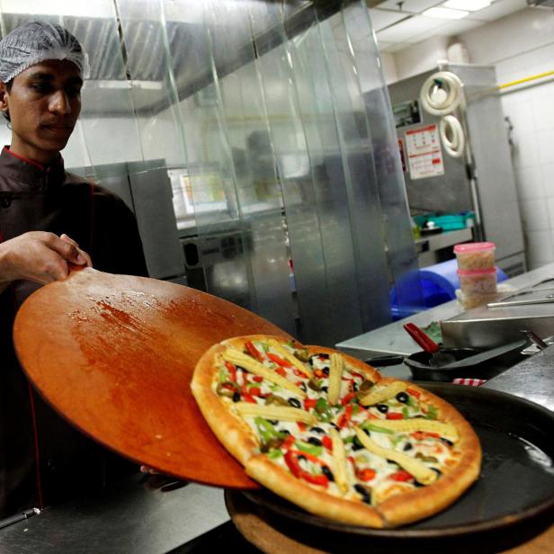 Mitarbeiter von Pizza Hut mit heißer Pizza