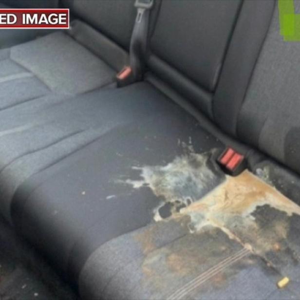 Essensreste und ein umgekippter Becher auf einem stark verschmutzten Rücksitz, angeblich als KI-generierter Beweis für eine Schadensersatzforderung bei Lyft verwendet.
